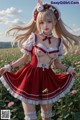 A woman in a red and white dress standing in a field of flowers.